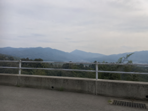 曇り空の、柵越しにみえる山の景色